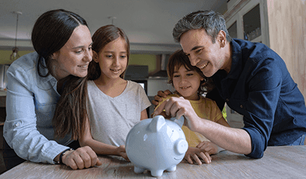 Family putting money in a piggy bank